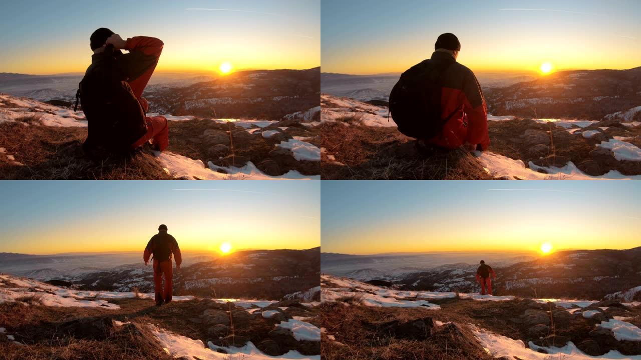 美丽迷人的日落冬日山脉。一个背着背包的男人在雪上假期进行运动远足