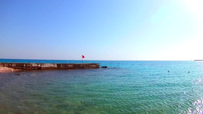 埃及红海码头上的危险红旗。晴天有风，角度宽。慢动作，标准动作。天际线