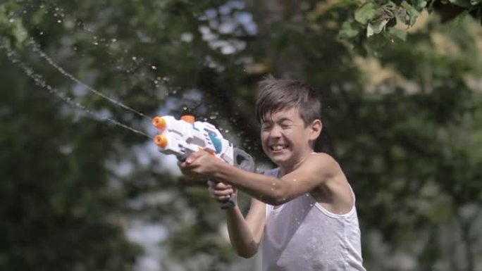 快乐男孩在村里户外射击水枪