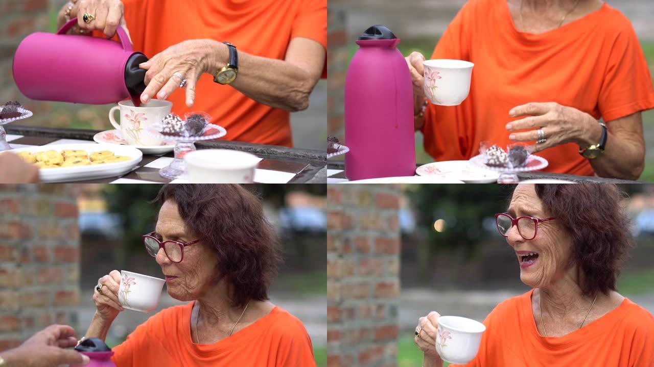 成熟的女人在户外野餐时喝茶
