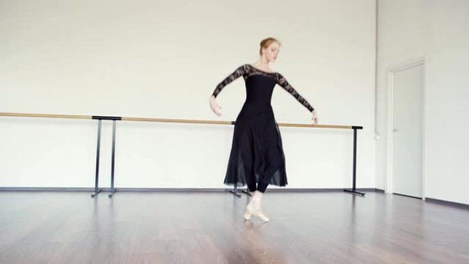 穿着足尖鞋的专业芭蕾舞演员在芭蕾舞工作室排练舞蹈。女芭蕾舞演员在练习中穿着黑色蕾丝紧身衣和长裙