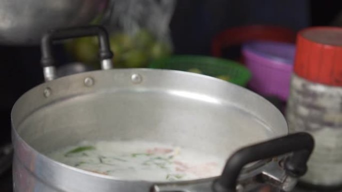 泰国高良姜鸡汤放在沸腾的锅里。将生鸡肉放入锅中。慢动作