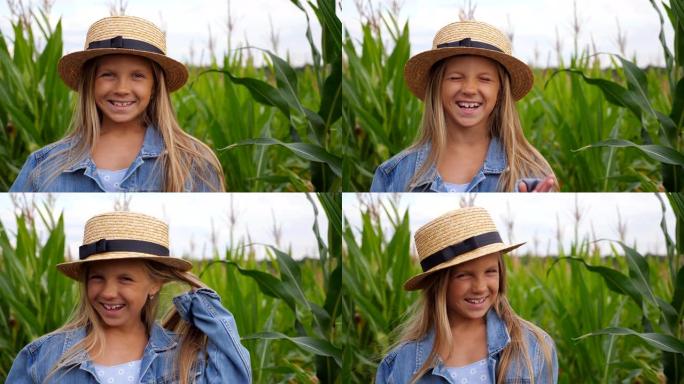 戴着草帽的滑稽小女孩看着镜头，在玉米田上笑着捂着脸。快乐的小孩玩她长长的金发和拉直她的草帽的肖像。