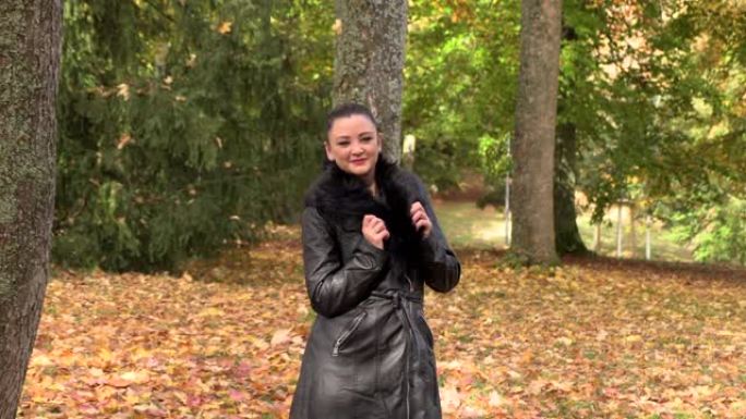 秋天公园里穿着黑色斗篷的好女孩