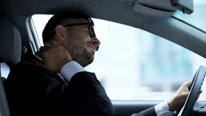 商务司机坐在驾驶座上按摩麻木的脖子，久坐的生活方式