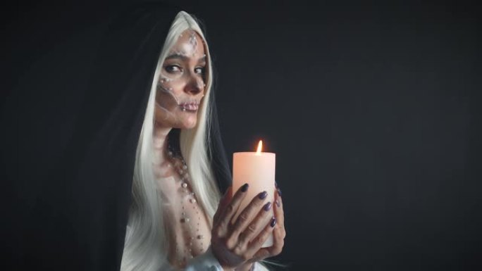 亡灵女祭司手持燃烧的蜡烛，举行迎接亡灵的仪式