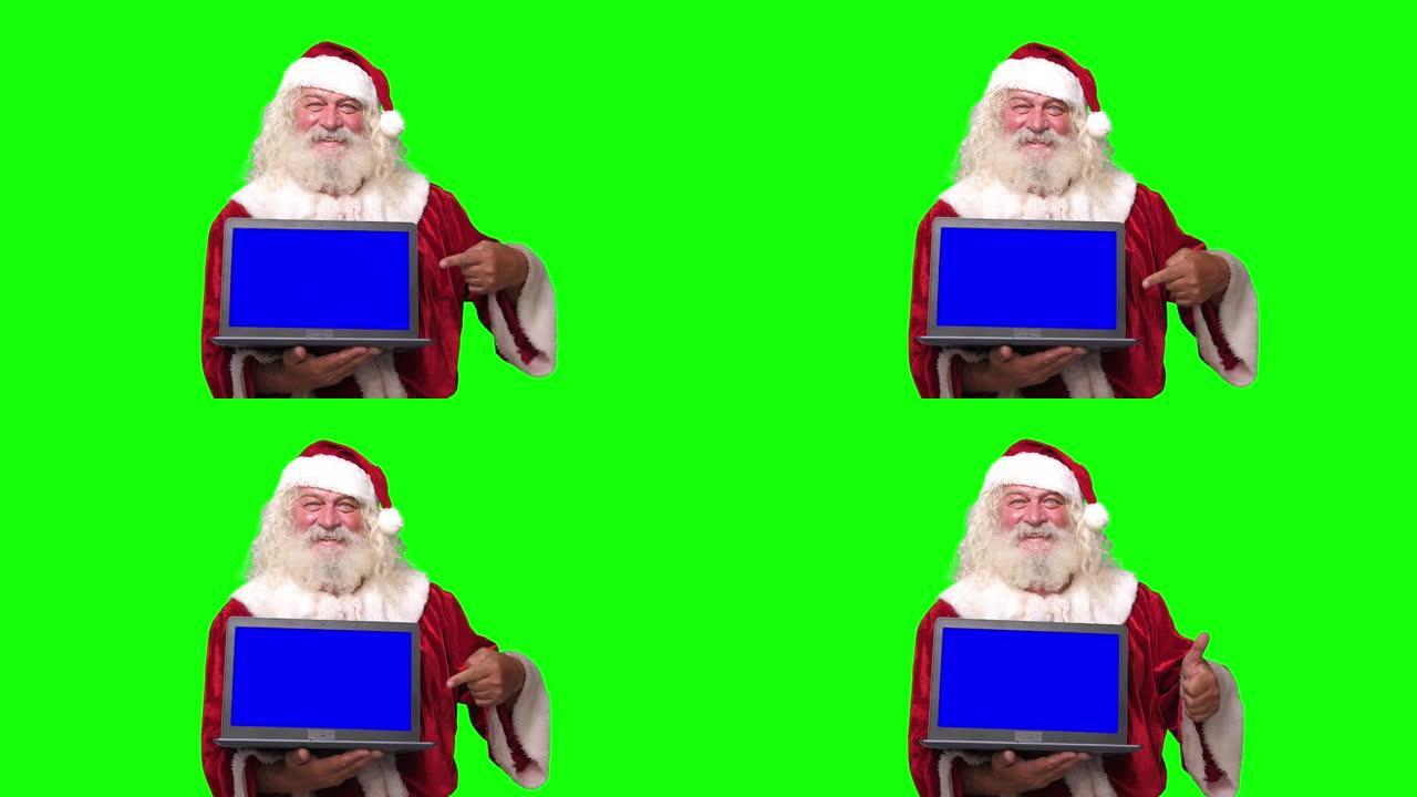 圣诞老人拿着一台笔记本电脑，蓝屏指向它色度键绿色屏幕背景