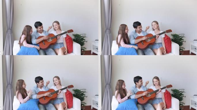 幸福的家庭，母亲，父亲和小女孩坐在沙发上，一起弹吉他