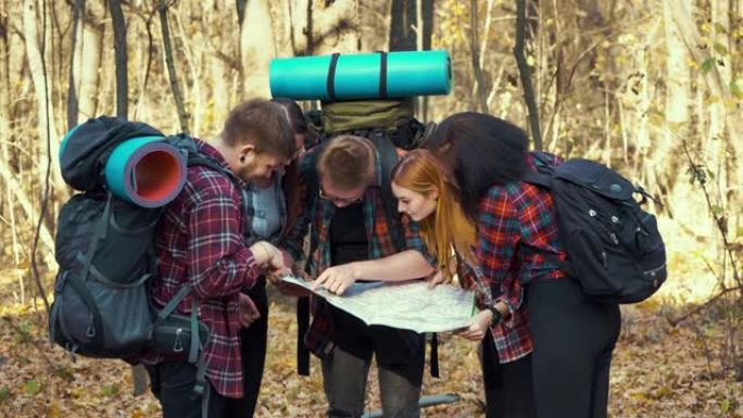年轻的徒步旅行者在秋季森林中寻找正确方向的地图