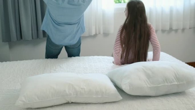 幸福的家庭，父女小女孩躺在卧室的白色床上玩耍