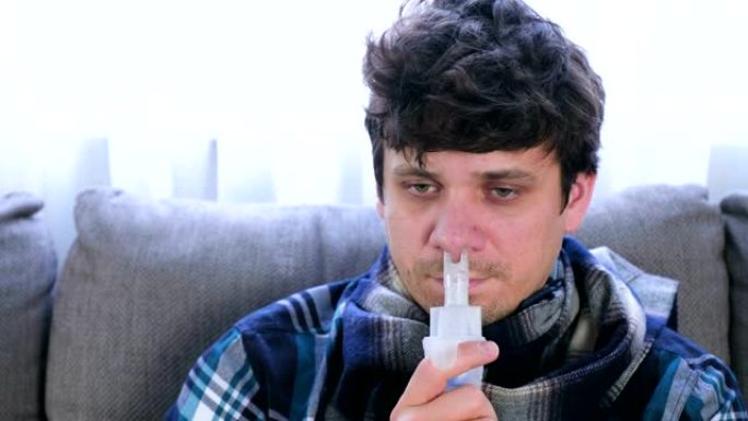病人通过吸入器喷嘴吸入鼻子坐在沙发上。特写脸，前视图。使用雾化器和吸入器进行治疗。