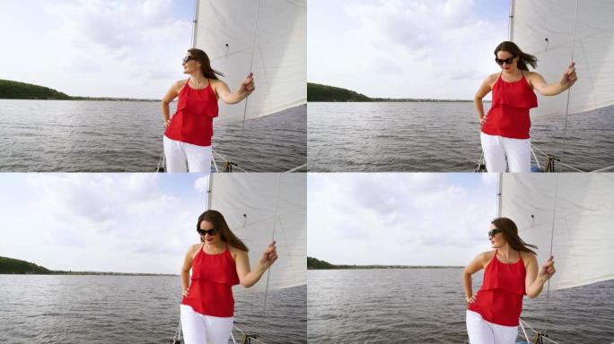 穿着夏装的女人在帆船上享受航行