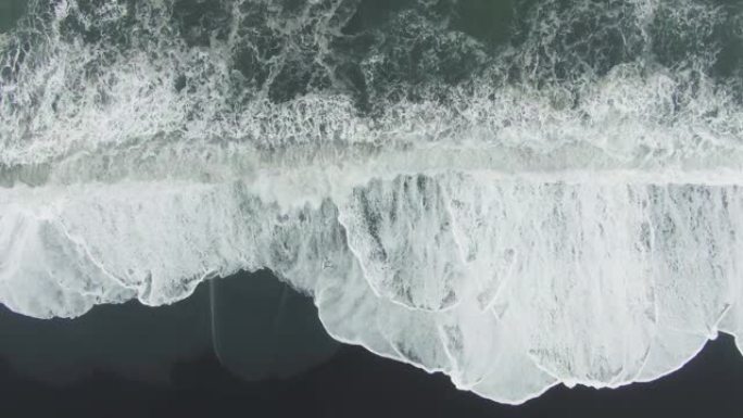 海浪汹涌。冰岛雷尼斯法拉黑海滩。空中自上而下的视图