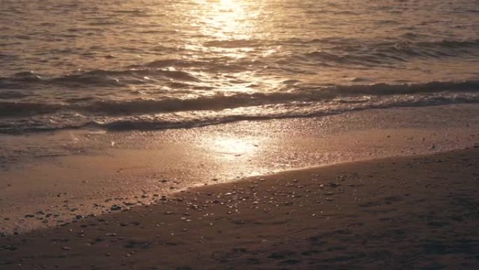 意大利奥斯蒂亚海滩上美丽的日落。夕阳下的海浪和沙子