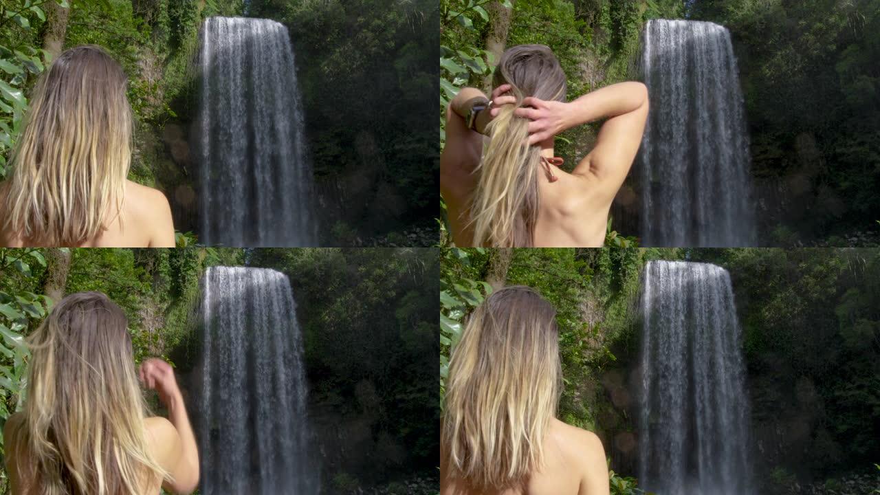 迷人的金发女孩在昆士兰的背景下翻转头发。澳大利亚。用红色相机拍摄，慢动作。