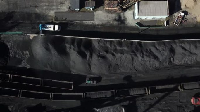 春天，2019-纳霍德卡，滨海边疆区。煤炭港口顶视图。使用挖掘机将煤炭装载到铁路货车中。装卸公司。
