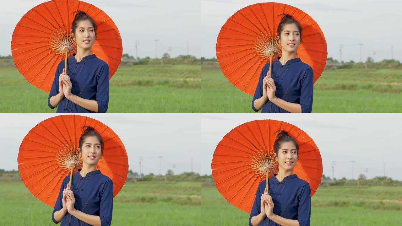 泰国妇女穿着传统风格的红色雨伞。