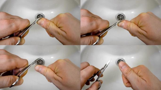 男性早上用剪刀在洗手盆或洗手盆上剪指甲