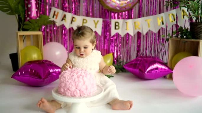 微笑的女婴在他的一岁生日时吃蛋糕