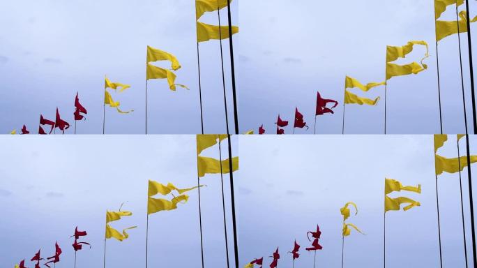 在夏季节日期间，在天空背景的旗杆上飘扬五颜六色的横幅