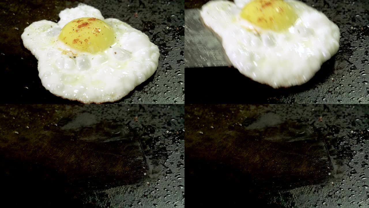 在热油铸铁烤架上煎炸碎鸡蛋的特写镜头。4K