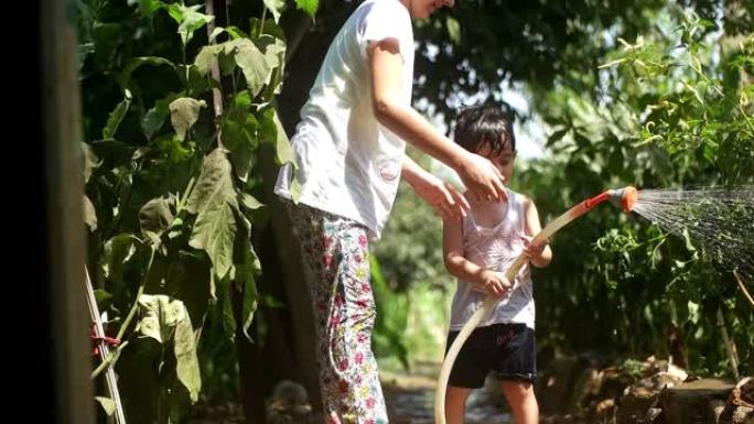 蹒跚学步的孩子在夏天在户外玩水管