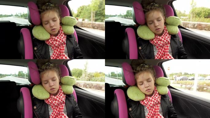 童年公路旅行和人们的概念 -- 十几岁的女孩睡在带旅行枕头的婴儿汽车座椅上