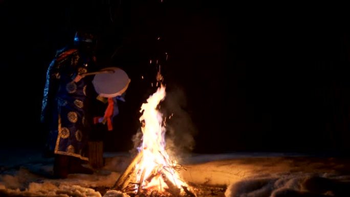萨满在火炉旁跳仪式舞。