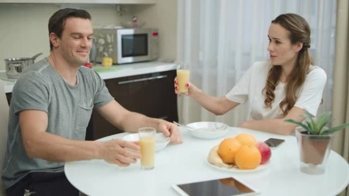 开朗的夫妇用橙汁欢呼。
