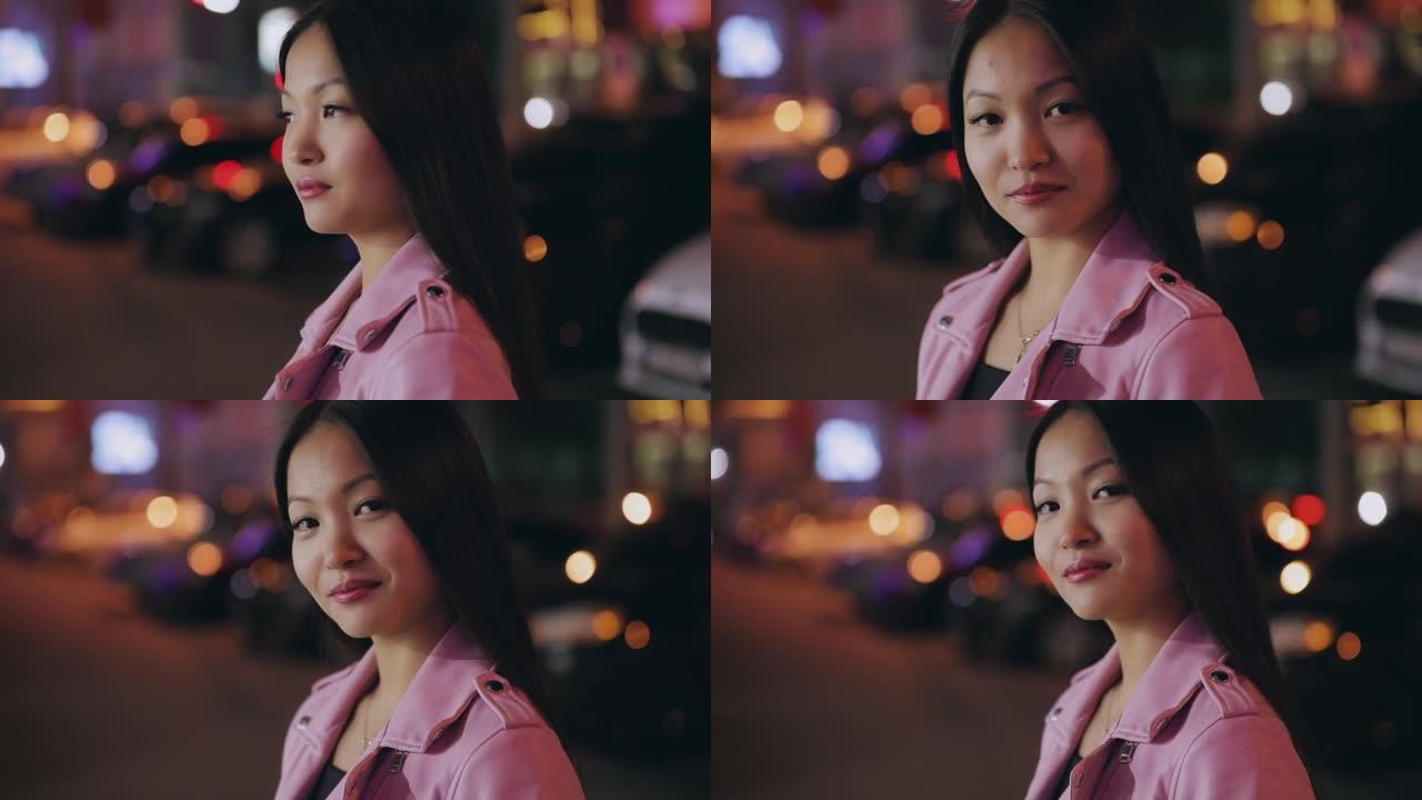 夜城美丽的亚洲女人的肖像转脸看着相机