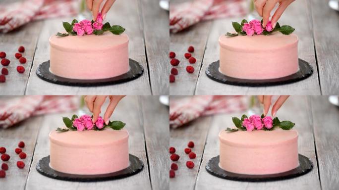 糖果用玫瑰装饰粉色蛋糕。