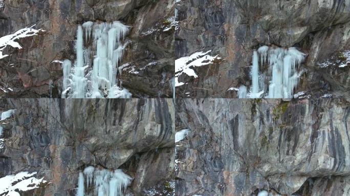 峡谷中陡峭的石墙上的冰瀑布。