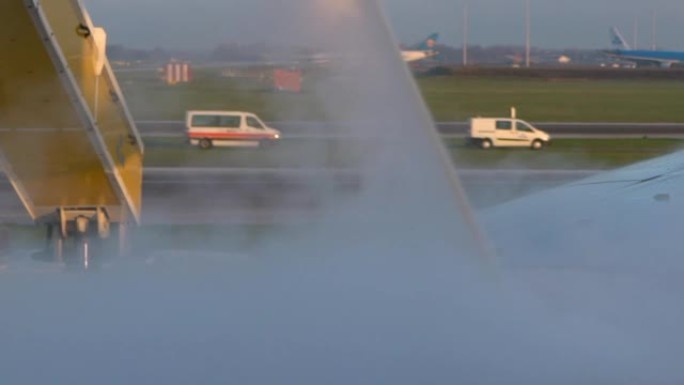 飞机机翼上的慢动作喷洒除冰器。平面防冰处理。