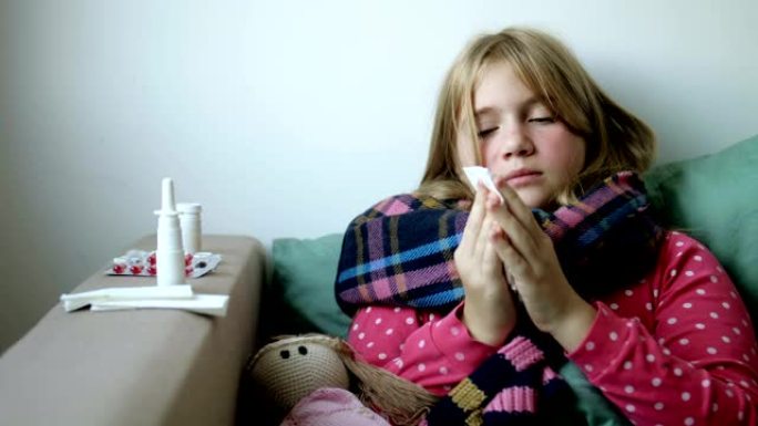 生病的女孩在塑料瓶和餐巾纸中拿着滴鼻剂。家庭治疗。不快乐的孩子使用有效的药物，喷雾和流鼻涕的补救措施