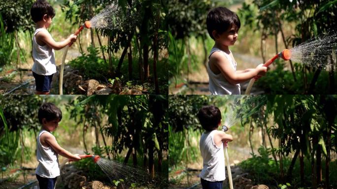 蹒跚学步的孩子在夏天在户外玩水管