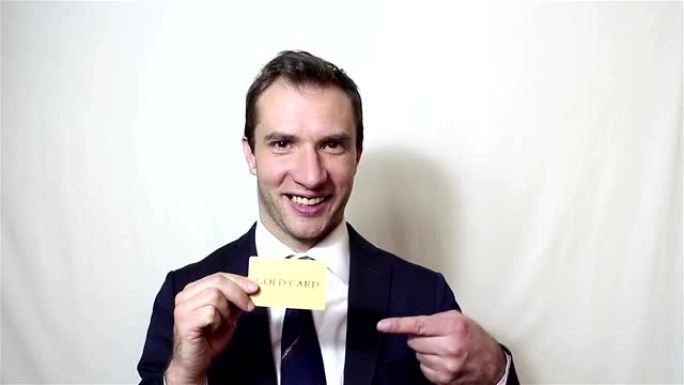 年轻英俊的商人展示他的金色信用卡。