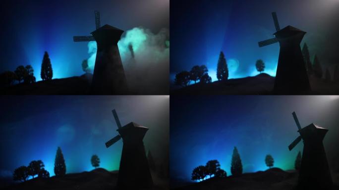 站在山上的风车剪影映衬着夜空。夜间装饰，山上有旧风车，带恐怖色调的雾气背景。恐怖概念