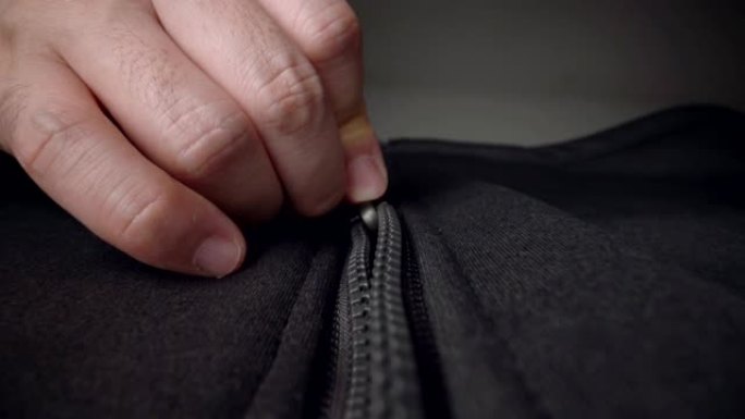 用手解开毛衣夹克拉链的极端特写拉链。