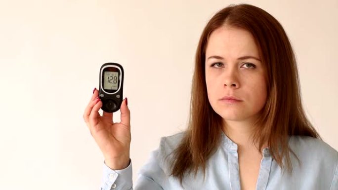 一个糖尿病女孩拿着血糖仪，血糖水平很高。