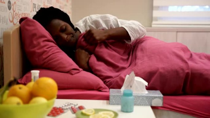 生病的女人躺在床上，发热高，感冒，被盖着毯子。