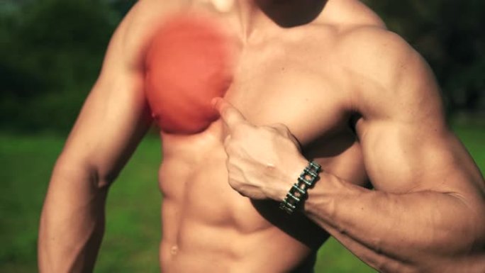 英俊的赤膊健美运动员在健身房艰苦训练后显示胸部发炎。运动员肌肉组织发炎。运动或比赛时的运动创伤。患有
