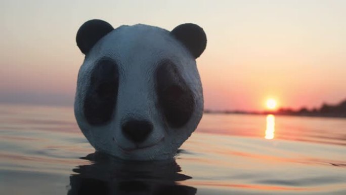 男子在暑假戴着熊猫头面具在海里