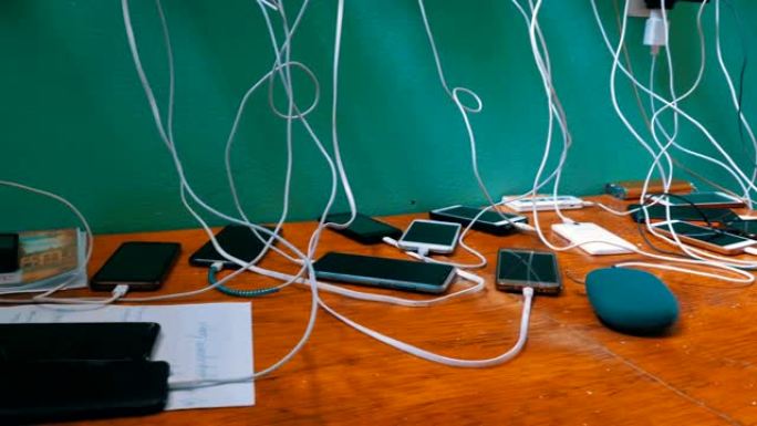 许多智能手机和手机在桌子上充电