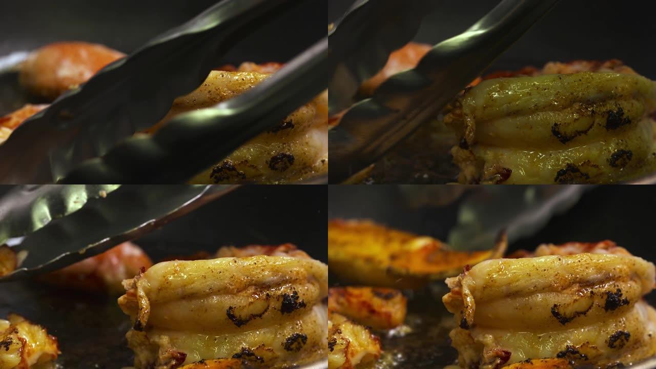 厨房厨师在煎锅里煎龙虾。我们只能看到厨师的手在煎锅上转动甲壳类动物-特写视图-烹饪概念