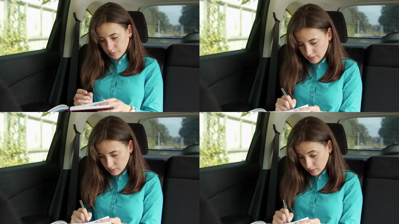 汽车中的女人在个人组织者中写笔记