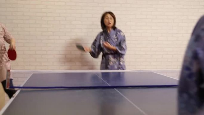 亚洲人穿着浴衣打乒乓球