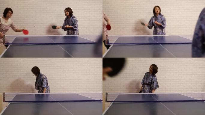 亚洲人穿着浴衣打乒乓球