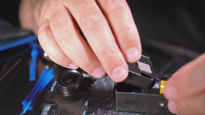 小型电子维修。组装拆卸的行动摄像机的人的手的特写视频。