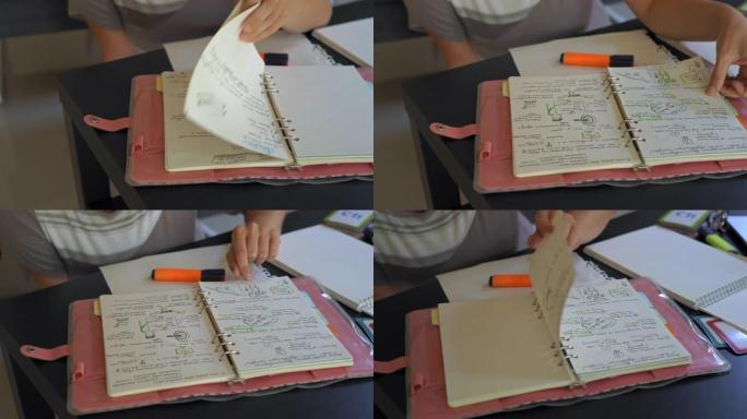 家庭教师或母亲翻阅笔记本上写满家庭教育笔记的页面。家庭教育理念。家庭教育概念
