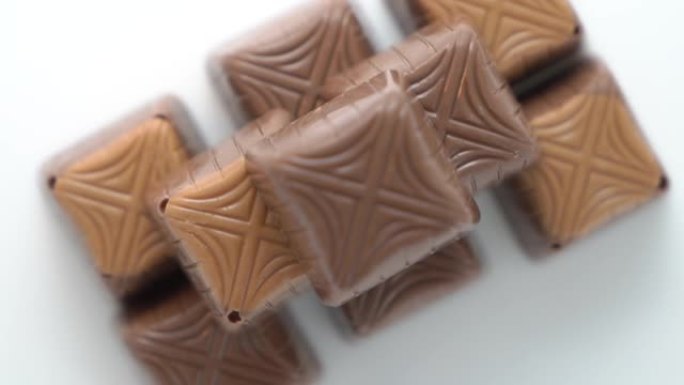 巧克力糖果金字塔旋转白色背景特写。